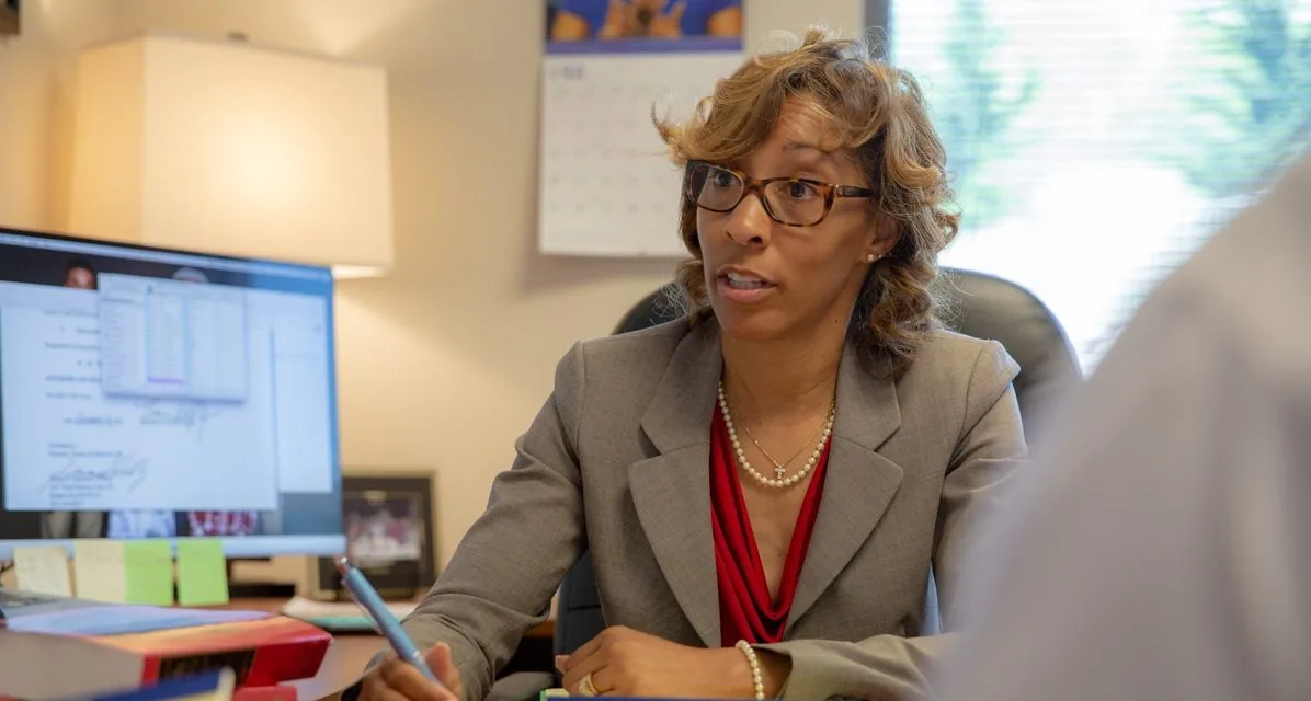 Christi Bright working through a file with a client at her desk